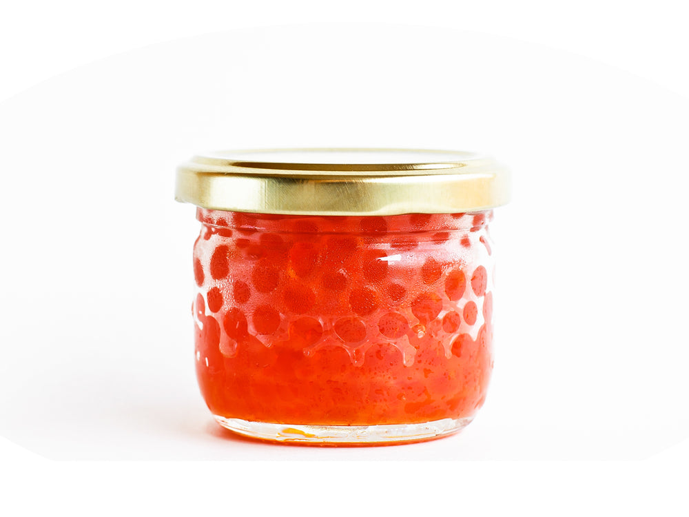 Alaskan Coho Salmon Caviar is delivered next-day in a glass jar with gold lid. The bright salmon colored roe is also called Ikura.