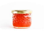 Alaskan Coho Salmon Caviar is delivered next-day in a glass jar with gold lid. The bright salmon colored roe is also called Ikura.